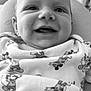 baby, smiling, face, infant, onesie, clothing, mickey_mouse, pattern, indoor, portrait, cute, happy, child, person, black_and_white, closeup, soft_light, young, baby_garment, expression