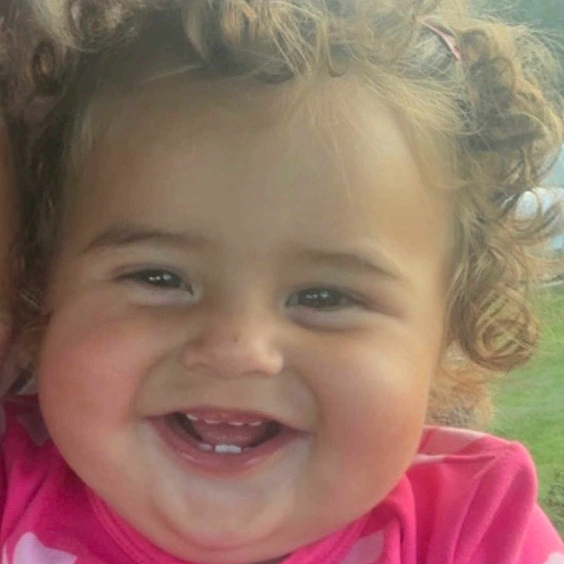 Giyana joined the competition — help win amazing prizes! toddler, child, smiling, curly_hair, pink_shirt, teeth, face, portrait, happy, indoors, window, car, natural_light, cute, baby, person, cheerful, closeup, skin, expression