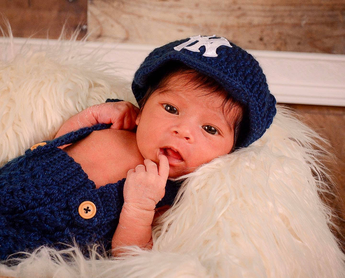 Aaron is registered to the contest to win money with this photo: azure, baby, baby_toddler_clothing, cap, comfort, costume_hat, couch, eye, fur, fur_clothing, happy, head, headpiece, knit_cap, lip, outerwear, person, skin, textile, toddler