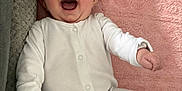 Anna joined the competition — help win amazing prizes! baby, infant, smiling, laughing, onesie, white_clothing, pink_blanket, soft_texture, cushion, cozy, happy, child, face, mouth_open, indoor, cute, young, person, lying_down, joyful