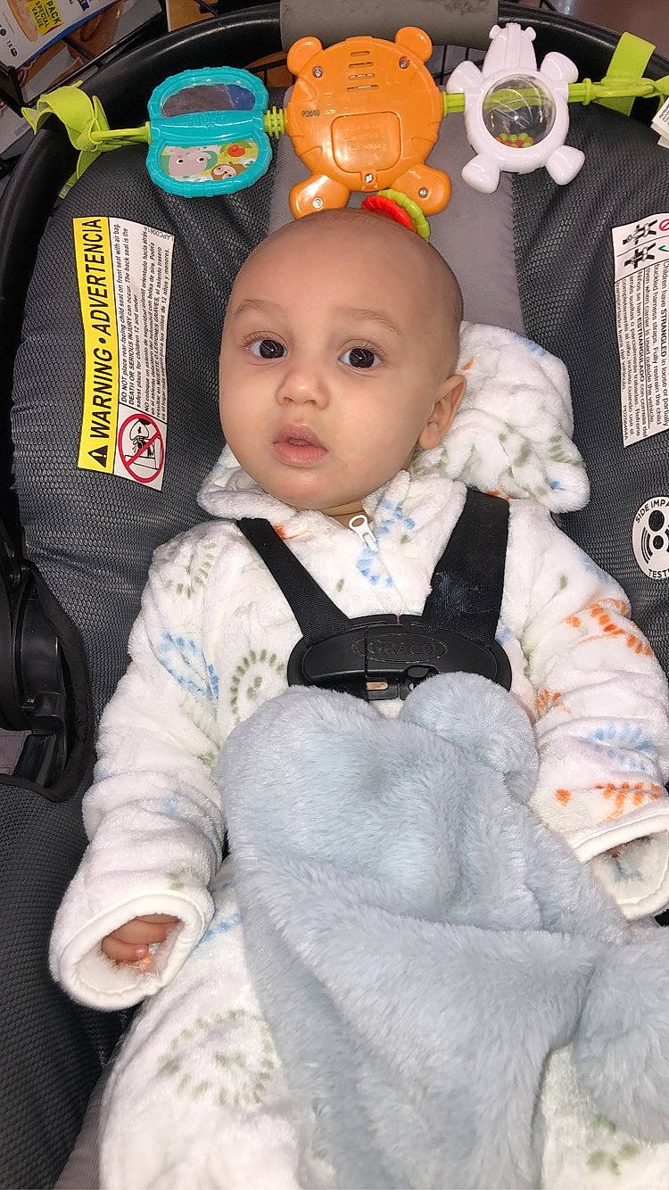 Daxton is registered to the contest to win money with this photo: baby, baby_products, baby_toddler_clothing, baby_toys, car_seat, chair, cheek, child, doll, formal_wear, fur, orange, pattern, person, plush, sitting, sleeve, stuffed_toy, textile, toddler