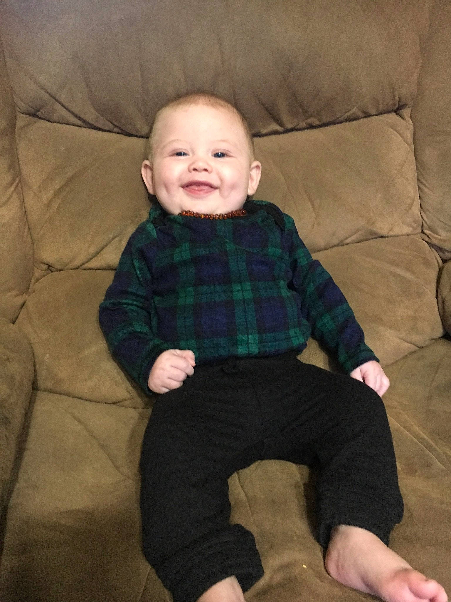 Finnegan is registered to the contest to win money with this photo: baby, cheek, child, design, face, head, leg, pattern, person, plaid, sitting, skin, sleeve, smile, tartan, textile, toddler