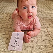 Maylie a rejoint le concours — aidez-le/la à gagner de superbes lots ! baby, blue_eyes, child, crawling_position, curious_expression, cute, face, floor, hair, hands, home, indoor, infant, milestone_card, patterned_mat, pink_shirt, portrait, skin, tile_floor, young