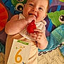Maylie participe au concours pour gagner de l'argent avec cette photo : baby, bib, blue, card, child, colorful_mat, cute, face, floor, green, hand, happy, infant, lying_down, onesie, orange, playing, red_toy, six_months, smiling