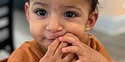 Enzo is registered to the contest to win money with this photo: child, toddler, face, hands, brown_shirt, indoor, closeup, cute, smile, eyes, skin, hair, person, portrait, table, wood, playing, expression, young, happy