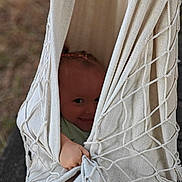 Manon participe au concours pour gagner de l'argent avec cette photo : baby, cheeky, child, cute, fabric, fun, grip, hammock, hand, hide_and_seek, netting, outdoor, peekaboo, playful, recreation, smile, texture, toddler, wooden_floor, young_child