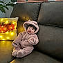 Skyler is registered to the contest to win money with this photo: baby, child, onesie, fluffy_clothing, couch, pillow, pumpkin, lights, smiling, tongue_out, indoor, cozy, autumn, cute, face, person, hood, furniture, home, plant