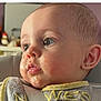 Grey is registered to the contest to win money with this photo: baby, close_up, face, bib, food, messy, high_chair, child, earring, curious, expression, skin, head, mouth, eyes, clothing, infant, young_child, indoor, portrait