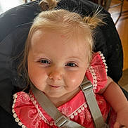 Leila joined the competition — help win amazing prizes! toddler, child, baby, high_chair, pink_dress, pigtails, smile, face, straps, indoors, cute, person, young_child, happy, rosy_cheeks, portrait, hair, eyes, clothing, seat