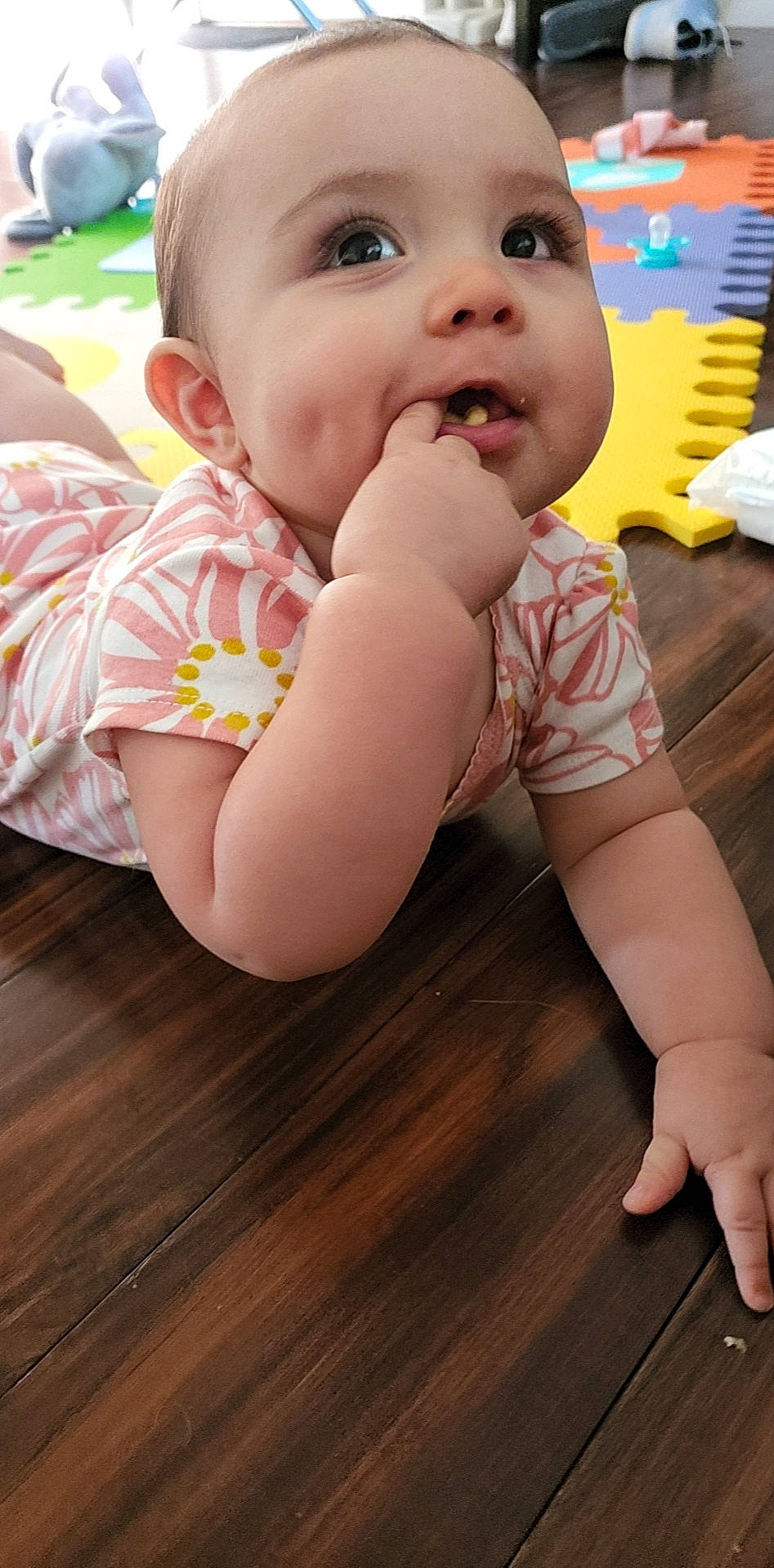 Rosa Josephine is registered to the contest to win money with this photo: baby, baby_toddler_clothing, cheek, child, finger, floor, flooring, happy, hardwood, head, iris, laminate_flooring, leisure, mouth, nose, person, skin, smile, toddler, wood