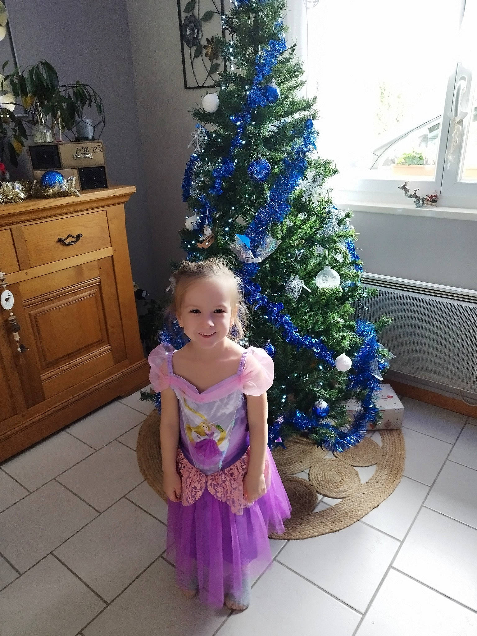 Victoire a rejoint le concours — aidez-le/la à gagner de superbes lots ! baby_toddler_clothing, blue, cabinetry, christmas_decoration, christmas_ornament, christmas_tree, dress, electric_blue, event, evergreen, happy, holiday_ornament, joy, ornament, person, photograph, plant, purple, smile, snapshot