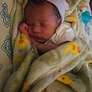 Karter is registered to the contest to win money with this photo: baby, blanket, sleeping, newborn, hat, bed, bedding, pattern, cozy, infant, wrapped, resting, child, person, soft, indoor, cute, peaceful, closeup, warm