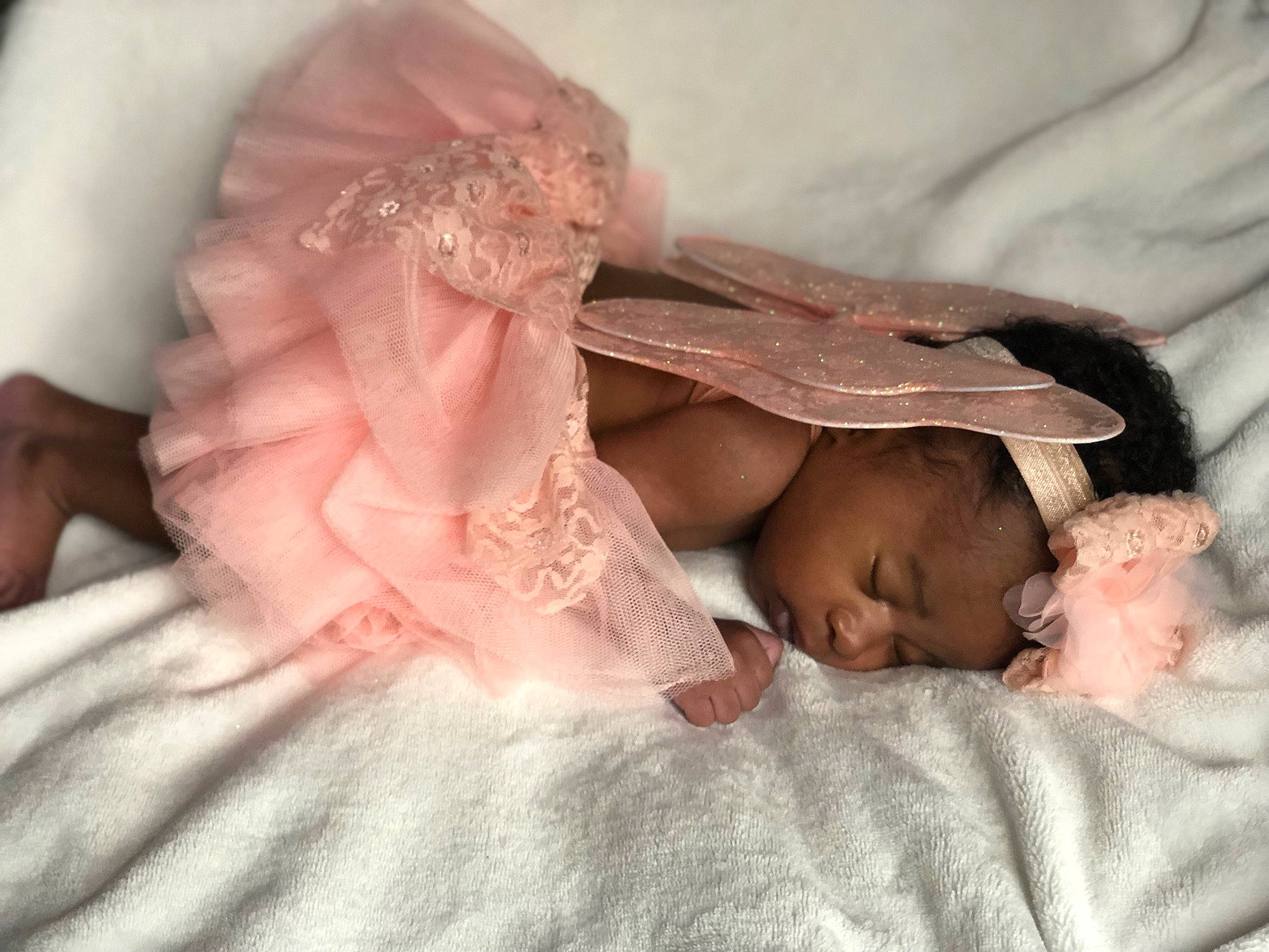 Iris is registered to the contest to win money with this photo: baby, bed, bedding, comfort, dress, ear, embellishment, eye, finger, fur, gesture, hand, human_body, iris, leg, linens, lip, nail, person, pink