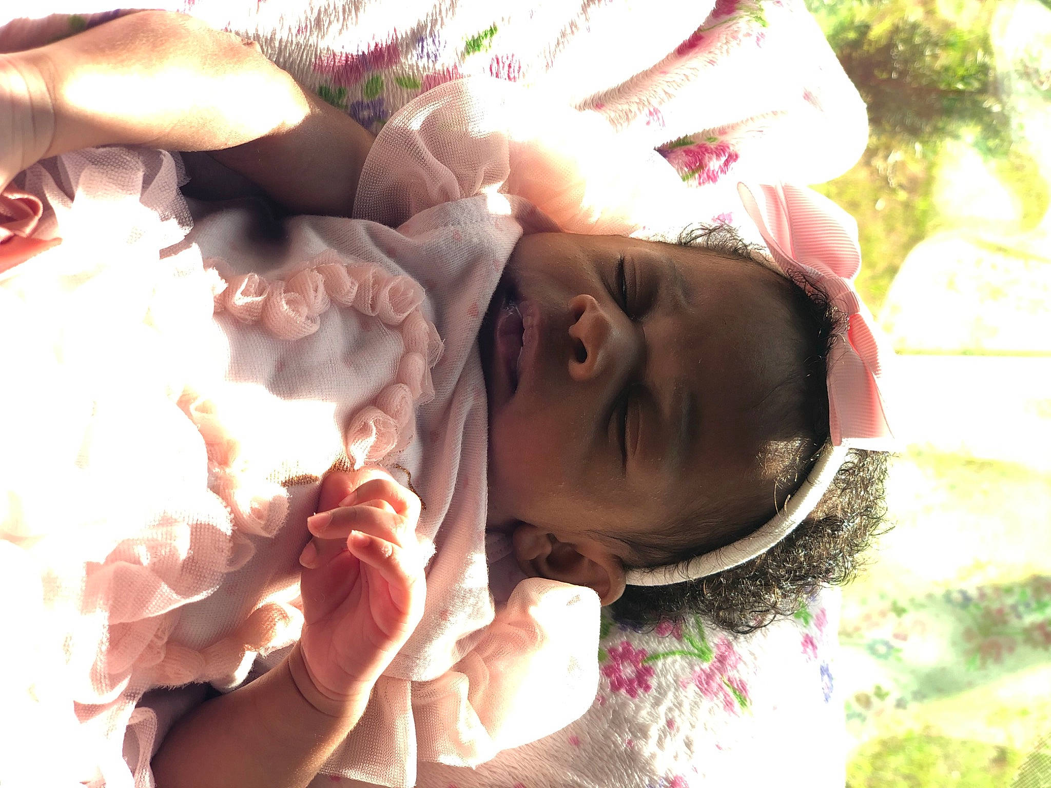 Iris is registered to the contest to win money with this photo: baby, baby_toddler_clothing, child, finger, flesh, fun, gesture, grass, hand, happy, nail, pattern, people_in_nature, person, petal, pink, rose_family, rose_order, skin, thumb