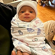 Avalynn is registered to the contest to win money with this photo: newborn, baby, infant, wrapped, blanket, hat, hospital, hand, person, wooden_floor, bed, wheel, indoor, cute, portrait, face, human, small, newborn_baby, child