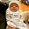 newborn, baby, infant, wrapped, blanket, hat, hospital, hand, person, wooden_floor, bed, wheel, indoor, cute, portrait, face, human, small, newborn_baby, child