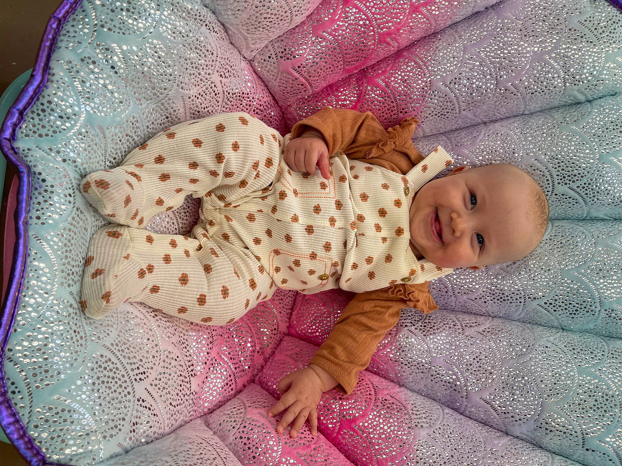 Gianni is registered to the contest to win money with this photo: baby, baby_products, baby_sleeping, baby_toddler_clothing, bedding, comfort, dress, face, facial_expression, head, human_body, joy, linens, pattern, person, pink, purple, skin, sleeve, textile