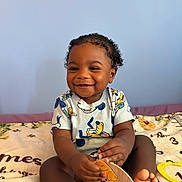 Kayden joined the competition — help win amazing prizes! toddler, baby, smiling, curly_hair, child, sitting, blanket, wooden_sign, indoor, happy, cute, person, clothing, foot, hand, face, portrait, toy, colorful, young_child