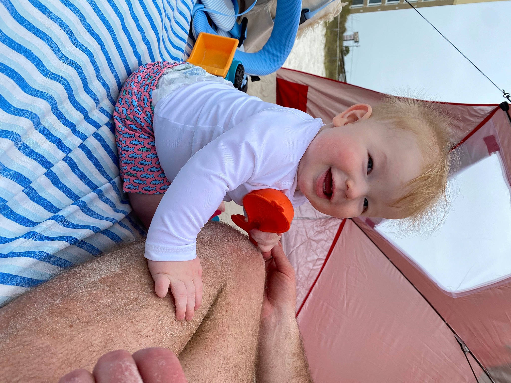 Hudson is registered to the contest to win money with this photo: abdomen, baby, child, comfort, elbow, foot, fun, happy, human_leg, joint, knee, leisure, nail, orange, person, skin, smile, t_shirt, thigh, thumb