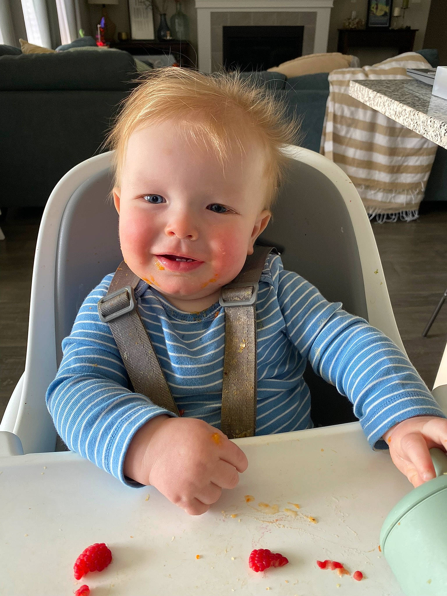 Hudson is registered to the contest to win money with this photo: baby, baby_toddler_clothing, chair, cheek, child, dishware, dress, eye, finger, flooring, fun, joy, person, product, sharing, sitting, skin, smile, t_shirt, table