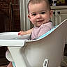 Olivia is registered to the contest to win money with this photo: baby, high_chair, smile, indoor, child, face, person, furniture, home, cozy, curious, skin, clothing, head, happy, photography, table, seat, modern, living_room