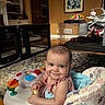Olivia joined the competition — help win amazing prizes! baby, blanket, carpet, child, comfort, cute, expression, face, floor, furniture, home, indoor, infant, person, play, room, sitting, smiling, toy, walker