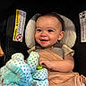 baby, blanket, car_seat, child, closeup, clothing, cute, face, happy, headrest, holding, indoor, infant, polka_dot, portrait, seatbelt, smiling, stuffed_animal, toddler, toy