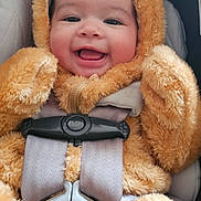 Olivia is registered to the contest to win money with this photo: baby, infant, child, car_seat, safety_harness, buckle, onesie, hood, fuzzy, plush, smile, happy, cheeks, face, closeup, portrait, seatbelt, cozy, cute, transportation