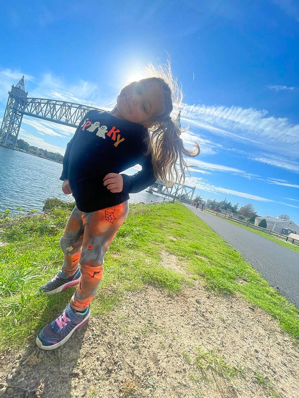 Shelby is registered to the contest to win money with this photo: asphalt, cloud, electric_blue, fun, grass, happy, horizon, human_leg, joy, knee, lake, landscape, leisure, people_in_nature, person, plant, recreation, sky, thigh, travel