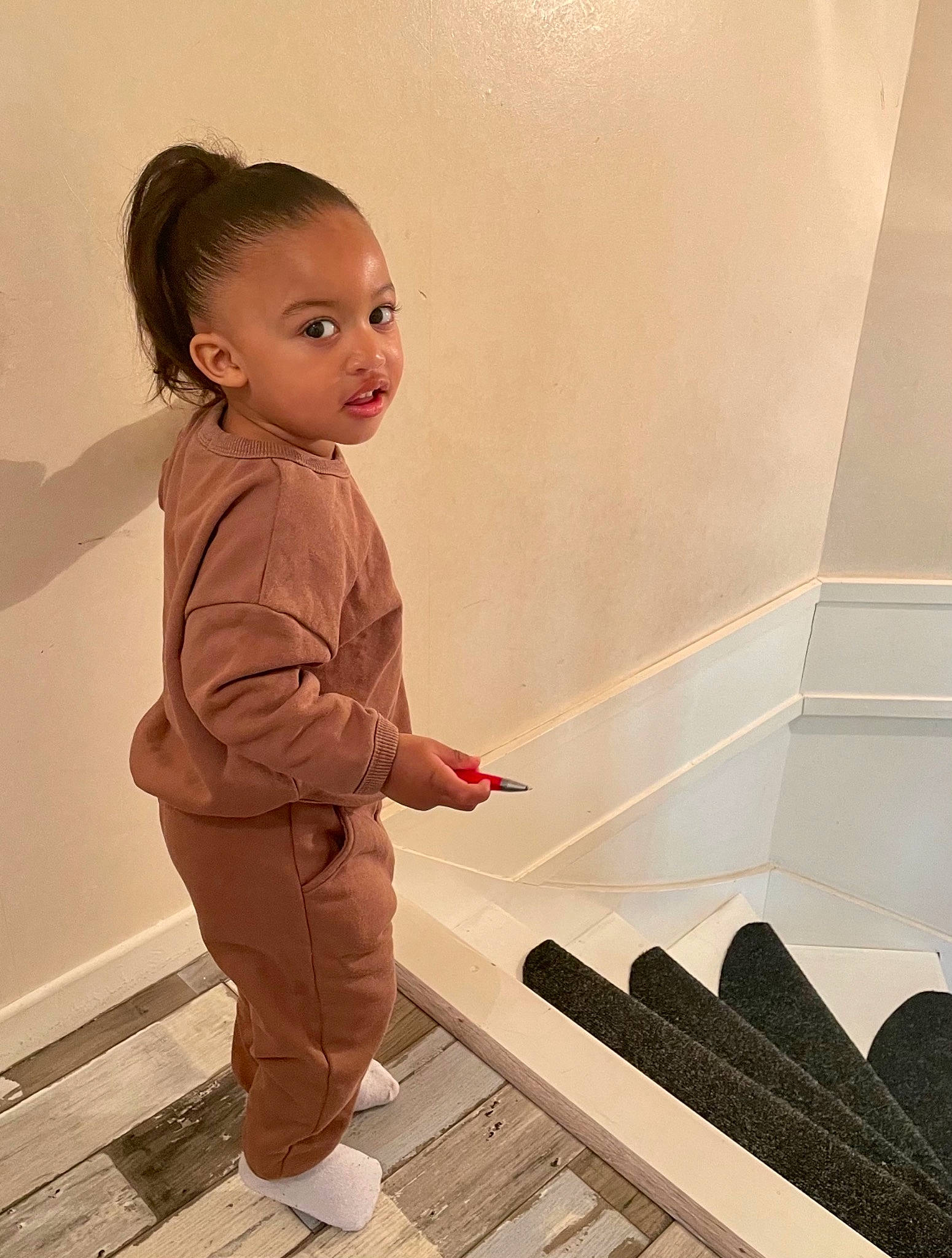 Maïa participe au concours pour gagner de l'argent avec cette photo : baby, baby_toddler_clothing, child, fashion_design, floor, flooring, fun, fur, hardwood, human_leg, pattern, person, room, sitting, sleeve, stairs, tile, toddler, waist, wood