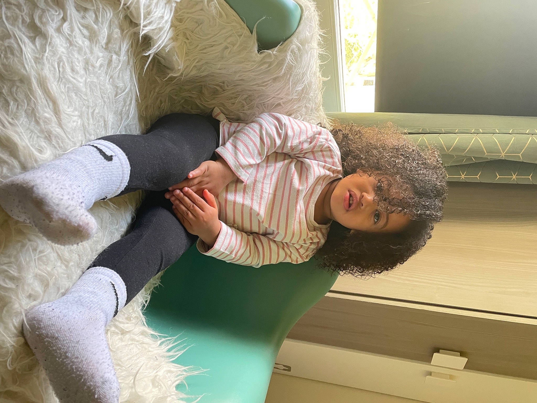 Maïa participe au concours pour gagner de l'argent avec cette photo : bedding, child, comfort, couch, elbow, fur, gesture, glasses, human_body, human_leg, knee, linens, nap, person, pillow, room, sitting, thigh, throw_pillow, wood