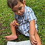 child, toddler, grass, food, chicken_nuggets, french_fries, outdoor, snack, barefoot, striped_shirt, curious, sitting, greenery, casual, daylight, plate, hand, foot, eating, park