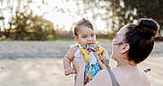 Marcello joined the competition — help win amazing prizes! baby, bow_tie, casual_wear, child, colorful_clothing, daylight, family, happy, holding, nature, outdoor, person, playful, portrait, sand, smile, sunlight, suspenders, trees, woman