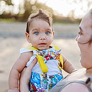 Marcello is registered to the contest to win money with this photo: baby, child, blue_eyes, colorful_clothing, bowtie, suspenders, adult_hand, outdoor, sunlight, portrait, holding, skin, expression, cute, person, infant, summer, nature, closeup, happy