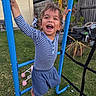 Marcello is registered to the contest to win money with this photo: child, playground, blue_bars, grass, outdoor, laughing, curly_hair, striped_shirt, blue_shorts, garden, pot_plants, fence, backyard, barefoot, happy, climbing, toy_stroller, person, summer, play