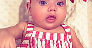 Leearnah is registered to the contest to win money with this photo: baby, bow, child, closeup, clothing, cute, expression, face, fashion, headwear, indoors, infant, person, portrait, red_headband, skin, smile, soft_blanket, striped_dress, young
