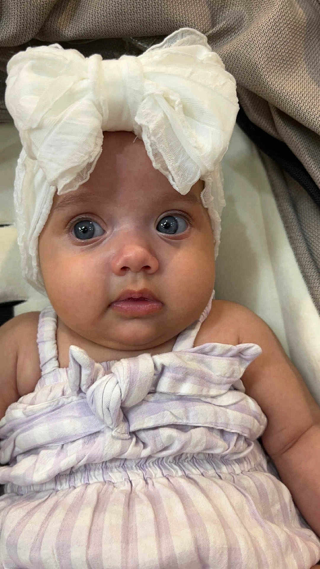 Leearnah is registered to the contest to win money with this photo: adorable, baby, blue_eyes, bow, child, closeup, clothing, cute, expression, face, headband, infant, innocent, person, portrait, sitting, skin, soft, striped, young