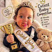 Leearnah joined the competition — help win amazing prizes! baby, child, toddler, portrait, smiling, tiara, crown, trophy, contest, sash, teddy_bear, stuffed_animal, indoor, seated, cute, cheeks, dessert, food, celebration, text_overlay