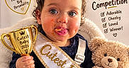 Leearnah joined the competition — help win amazing prizes! baby, celebration, cheeks, child, contest, crown, cute, dessert, food, indoor, portrait, sash, seated, smiling, stuffed_animal, teddy_bear, text_overlay, tiara, toddler, trophy