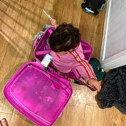Leearnah joined the competition — help win amazing prizes! bag, casual, child, clothing, curious, door, flooring, foot, footwear_absent, hand, indoor, luggage, person, pink_suitcase, room, small_object, toddler, top_view, toy, wooden_floor