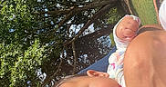 Leearnah is registered to the contest to win money with this photo: adult, baby, casual, child, clothing, curious_expression, daylight, face, family, grass, greenery, holding, nature, outdoor, park, person, portrait, smile, sunlight, trees