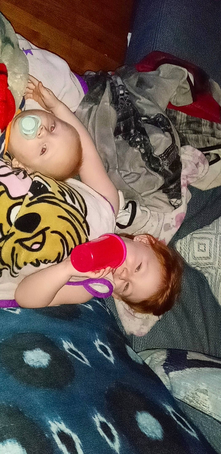 Alaia is registered to the contest to win money with this photo: baby_toddler_clothing, cheek, child, comfort, facial_expression, finger, fun, happy, human_leg, magenta, mouth, nail, person, pink, room, sitting, smile, thigh, toddler