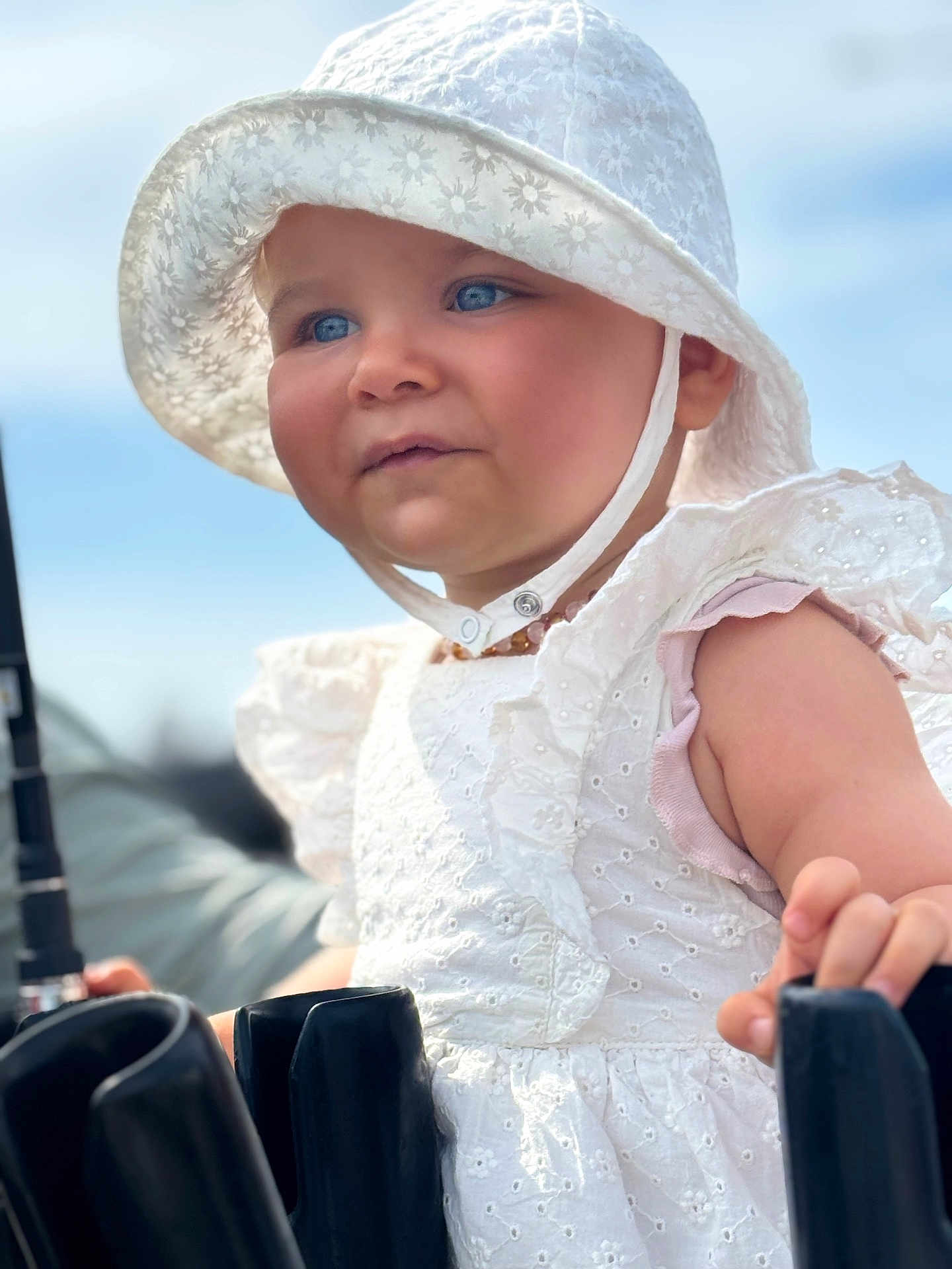 Ema a rejoint le concours — aidez-le/la à gagner de superbes lots ! toddler, child, face, blue_eyes, white_hat, white_dress, sun_hat, outdoor, summer, portrait, curious, cute, baby, skin, hand, clothing, sunlight, daylight, person, close_up