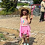 Lily Rose joined the competition — help win amazing prizes! cars, child, children, daylight, garden, girl, hockey_net, houses, outdoor, paved_driveway, peace_sign, pink_dress, playing, rocks, shoes, smiling, socks, straw_hat, sunny, trees