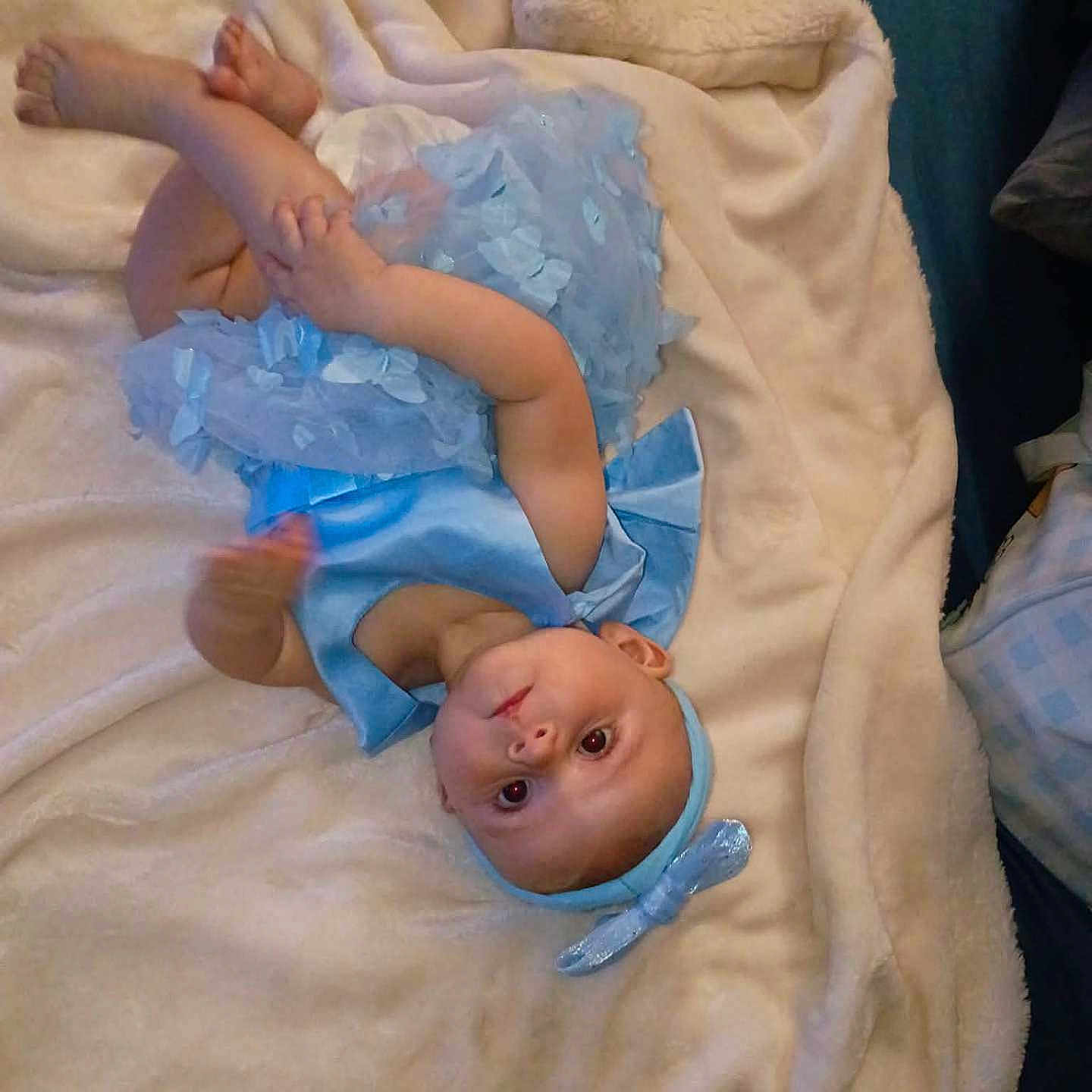 Harper joined the competition — help win amazing prizes! baby, infant, child, portrait, lying_down, upside_down, blanket, bed, blue_outfit, headband, ruffles, feet, toes, face, eyes, indoors, cozy, candid, baby_photography, soft_lighting