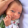 newborn, baby, infant, child, face, eyes, blue_eyes, sleeping, awake, hand, adult_hand, cradling, hospital, hospital_bracelet, floral_clothing, green_clothing, blanket, portrait, close_up, family