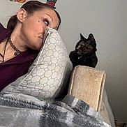 Lilith is registered to the contest to win money with this photo: woman, cat, pillow, couch, blanket, indoor, tattoo, necklace, furniture, pet, relaxation, curiosity, companion, home, casual, portrait, animal, cozy, resting, feline
