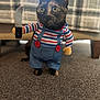 cat, costume, toy_knife, striped_shirt, denim_overalls, carpet, indoor, pet, animal, funny, playful, blurred_background, feline, small, standing, orange_button, plush, toy, eyes, ears