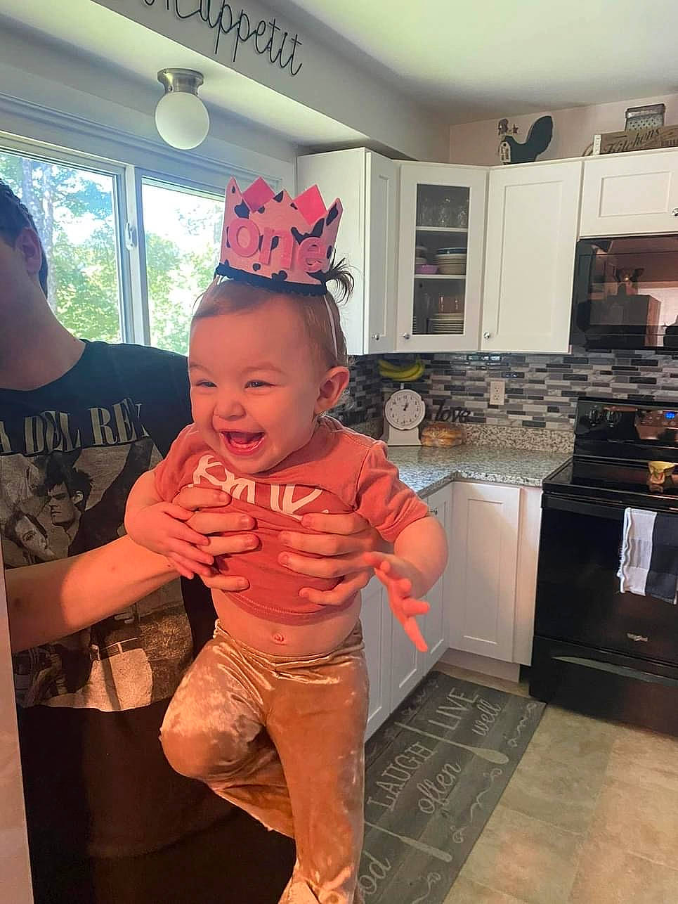 Madelynn is registered to the contest to win money with this photo: baby, cabinetry, cooking, cooktop, countertop, event, flooring, gas_stove, happy, hardwood, homemaker, kitchen, kitchen_appliance, kitchen_stove, orange, person, room, smile, stove, toddler