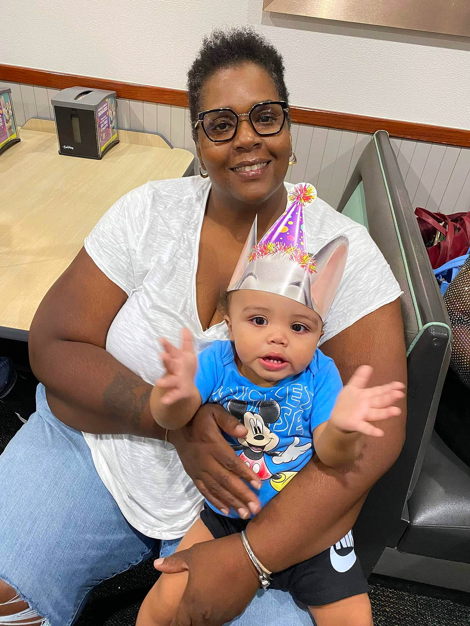 Kendrick is registered to the contest to win money with this photo: baby, chair, child, event, eyewear, fun, happy, hat, headwear, joy, lap, leisure, person, sandal, shorts, sitting, skin, smile, t_shirt, thigh